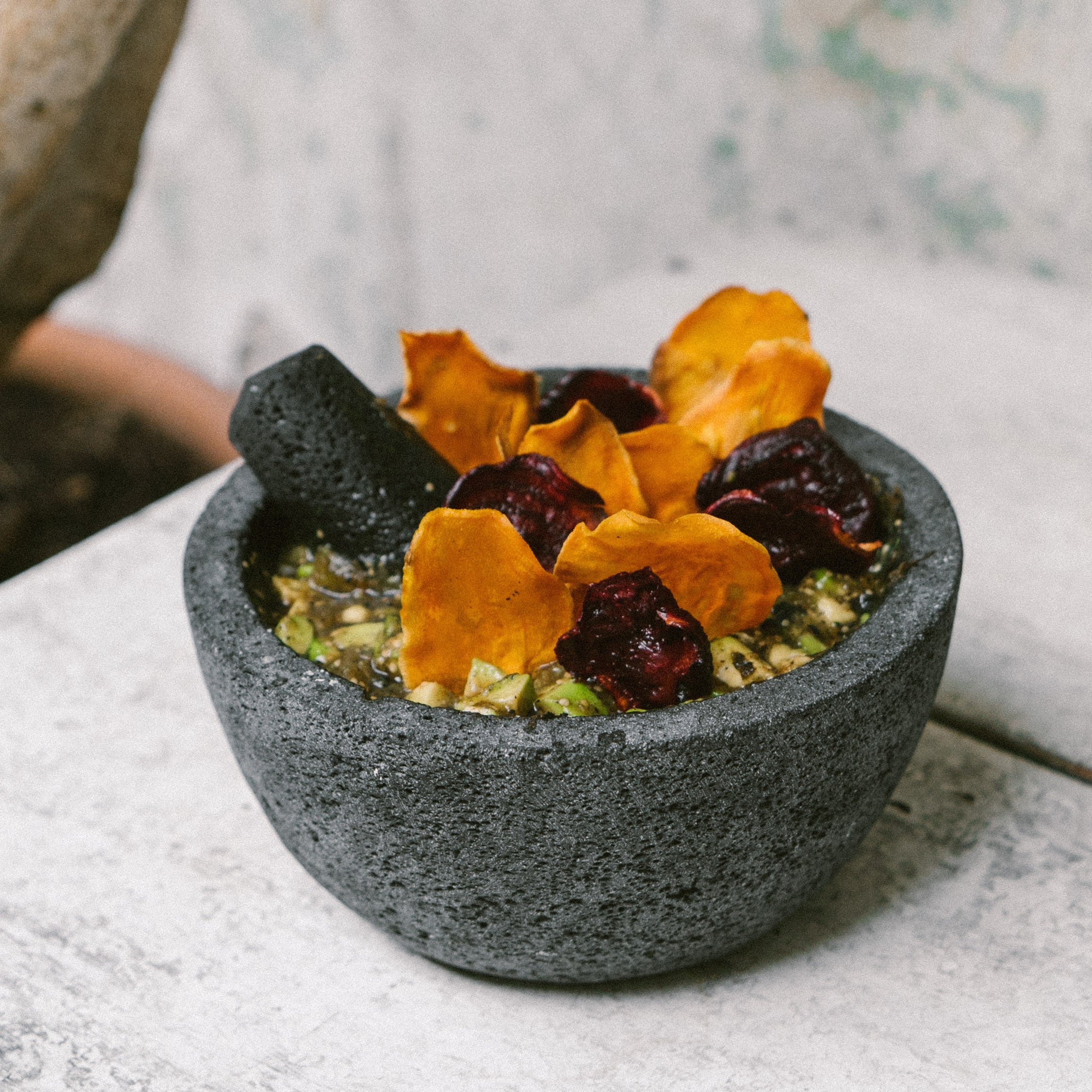 Salsa molcajeteada con chips de betabel y camote